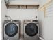 Well-equipped laundry area with front-load washer and dryer, complemented by a shelf and drying rack at 2930 S Birch St, Denver, CO 80222