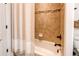 A well-lit bathroom featuring a shower with beige tile and a stylish curtain at 3214 Timeless Trl, Berthoud, CO 80513