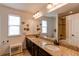 Bathroom with double sinks, granite countertops, and a large mirror at 3214 Timeless Trl, Berthoud, CO 80513