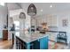 Stylish kitchen featuring a large island with granite countertops, pendant lighting, and white cabinets at 3214 Timeless Trl, Berthoud, CO 80513