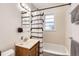 Cozy bathroom featuring a wood vanity and a shower tub with a patterned curtain at 1277 Wabash St, Denver, CO 80220