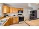 Well-lit kitchen features wooden cabinets, stainless steel refrigerator, and modern appliances at 1277 Wabash St, Denver, CO 80220