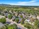 Community aerial view featuring a mix of home styles, mature trees, and a lush green landscape in the distance at 14091 W Exposition Dr, Lakewood, CO 80228