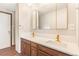 Bathroom featuring double vanity with quartz countertop, gold faucets and wood cabinets at 14091 W Exposition Dr, Lakewood, CO 80228