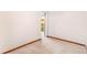A simple, carpeted bedroom with white walls and wood trim and a glimpse into the closet at 14091 W Exposition Dr, Lakewood, CO 80228