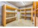 An empty closet with concrete floor and ceiling, and natural wood shelving units throughout at 14091 W Exposition Dr, Lakewood, CO 80228