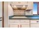 Bright kitchen with white cabinetry, vintage backsplash, and modern cooktop at 14091 W Exposition Dr, Lakewood, CO 80228