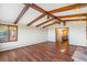 Open living space featuring hardwood floors, wood beams, and a classic stone fireplace at 14091 W Exposition Dr, Lakewood, CO 80228
