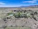 Expansive aerial view of sprawling ranch featuring multiple buildings, trees, and open land at 9445 Lykins Pl, Longmont, CO 80503