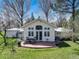 View of backyard featuring stone patio with seating, lawn and mature trees at 9445 Lykins Pl, Longmont, CO 80503