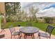 Landscaped backyard with a stone patio and wrought iron seating, great for outdoor entertaining at 9445 Lykins Pl, Longmont, CO 80503