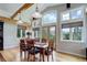 Sunlit dining area with wood floors, exposed beams, and a scenic view through large windows at 9445 Lykins Pl, Longmont, CO 80503