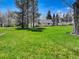 Expansive front yard with mature trees and lush green lawn showcasing the property's curb appeal at 9445 Lykins Pl, Longmont, CO 80503