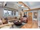 Spacious living room with wood flooring, exposed beams, and large windows at 9445 Lykins Pl, Longmont, CO 80503