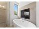 Bright bathroom featuring a standalone tub with a fireplace, offering a relaxing spa-like experience at 2564 S Carey Way, Denver, CO 80222