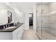 Modern bathroom with double sinks, a glass-enclosed shower, and access to a walk-in closet at 2564 S Carey Way, Denver, CO 80222