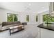 Bright living room with three windows, couch, light gray carpet and kitchen view at 2564 S Carey Way, Denver, CO 80222