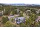 Aerial view showcases the home nestled among trees, boasting mountain views, and a large entertainment deck at 1423 Belford Ct, Evergreen, CO 80439