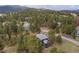 Aerial view of the home surrounded by mature trees in a tranquil setting, with expansive outdoor deck at 1423 Belford Ct, Evergreen, CO 80439
