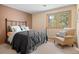 Cozy bedroom featuring a comfortable bed, chair and a window with a view of the outdoors at 1423 Belford Ct, Evergreen, CO 80439