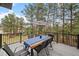 Outdoor deck with a wooden table and chairs surrounded by lush trees and blue skies at 1423 Belford Ct, Evergreen, CO 80439