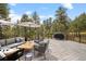 Relaxing outdoor deck with cozy seating area, grill, and beautiful views of surrounding trees at 1423 Belford Ct, Evergreen, CO 80439