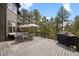 Expansive deck with comfortable seating and a grill overlooking a private, tree-filled backyard at 1423 Belford Ct, Evergreen, CO 80439
