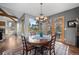 Cozy dining room featuring a chandelier, wood floors, a gray accent wall, and views of the outdoors at 1423 Belford Ct, Evergreen, CO 80439