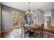 Charming dining area featuring a chandelier, wooden table, and access to outdoor deck at 1423 Belford Ct, Evergreen, CO 80439