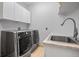 Well-lit laundry room features updated appliances, ample counter space and storage cabinets at 1423 Belford Ct, Evergreen, CO 80439