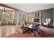 Bright living room with a fireplace, exposed beams, and access to an outdoor deck at 1423 Belford Ct, Evergreen, CO 80439