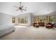 Spacious main bedroom with carpeted floors, multiple windows with wooded views, and comfortable seating at 1423 Belford Ct, Evergreen, CO 80439