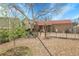 Landscaped backyard with gravel, a growing sapling, metal arch, and a brick home at 14867 E Harvard Ave, Aurora, CO 80014