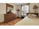 Bedroom featuring wood laminate flooring, a dresser with mirror, and bright natural light at 14867 E Harvard Ave, Aurora, CO 80014