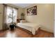 Bright bedroom featuring wood laminate flooring, a large bed with drawers, and bright natural light at 14867 E Harvard Ave, Aurora, CO 80014