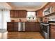 Traditional kitchen with stainless steel appliances, wood cabinets, and light wood floors at 14867 E Harvard Ave, Aurora, CO 80014