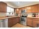 Bright kitchen with stainless steel appliances, wood cabinets, and a window over the sink at 14867 E Harvard Ave, Aurora, CO 80014