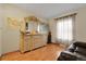 Living room area featuring a large decorative dresser and wood laminate floors at 14867 E Harvard Ave, Aurora, CO 80014