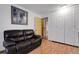 A cozy living room with a dark leather couch, wood laminate flooring, and a large storage closet at 14867 E Harvard Ave, Aurora, CO 80014