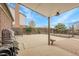 Covered patio area with a brick chimney and a fenced yard under a blue sky at 14867 E Harvard Ave, Aurora, CO 80014
