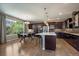 Open kitchen and dining area with dark cabinets, stainless appliances, an island, and a window with a backyard view at 2263 S Loveland St, Lakewood, CO 80228