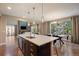 Open concept kitchen featuring an island with seating, stainless sink, and access to the living room at 2263 S Loveland St, Lakewood, CO 80228