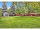 Lush backyard featuring mature trees, a storage shed, and a relaxing hammock at 11864 N Chase Ct, Westminster, CO 80020