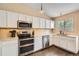 Well-lit kitchen features stainless steel appliances, white cabinetry, and dark wood flooring at 11864 N Chase Ct, Westminster, CO 80020