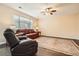 Cozy living room features hardwood floors, a ceiling fan, and two leather sofas at 11864 N Chase Ct, Westminster, CO 80020