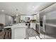 Spacious kitchen featuring stainless steel appliances, white cabinets, and a large island with breakfast bar at 1390 Everett Ct # 105, Lakewood, CO 80215
