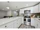 A well-designed kitchen with stainless steel appliances, white countertops, and modern cabinetry at 1390 Everett Ct # 105, Lakewood, CO 80215