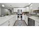 Updated kitchen with stainless steel appliances, stone countertops, tile backsplash, and modern cabinetry at 1390 Everett Ct # 105, Lakewood, CO 80215