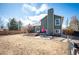 Spacious backyard with a patio, outdoor dining set and a beautiful green house with blue sky at 200 N Holcomb St, Castle Rock, CO 80104