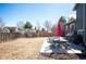 A spacious backyard with patio area, dining set, egg chair, and beautiful blue sky at 200 N Holcomb St, Castle Rock, CO 80104